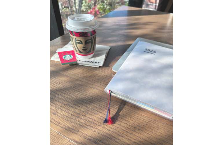 机に置かれたコーヒーと手帳